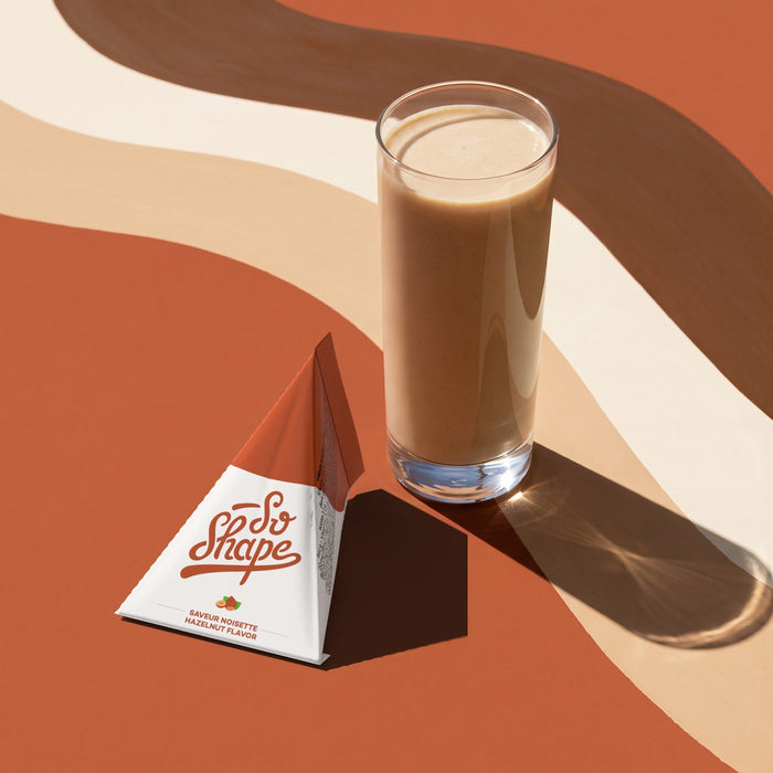Hazelnut shake in a glass next to its So Shape sachet