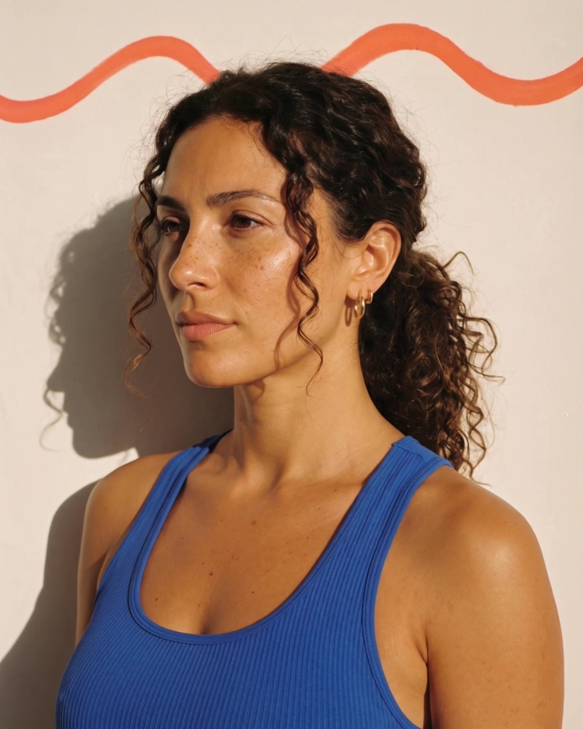 AI illustration: a woman with dark curly hair in a cobalt tank top, in warm sunlight against a cream wall
